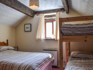 a bedroom with two bunk beds and a window at Swallow Cottage in Leek +6 photos