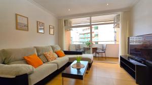 a living room with a couch and a tv at NEXTHOME Beach & Pool in Lloret de Mar