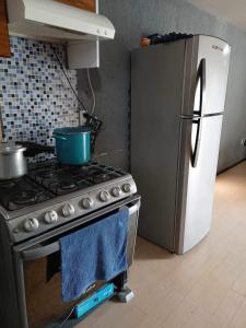 a kitchen with a stove and a refrigerator at La casa de Ile in San Juan Pueblo Nuevo