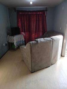 a couch sitting in a living room with a window at La casa de Ile in San Juan Pueblo Nuevo