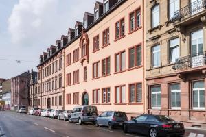 a row of cars parked in front of a building at High Level Apartment in Mannheim