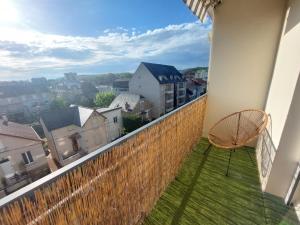 a balcony with a chair and a view of a city at Le Cosy Gaillard 3 étoiles, magnifique vue sur la ville, parking privé et proche du centre in Brive-la-Gaillarde