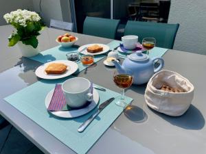 a table with plates of food and glasses of wine at Le temps des Pins in La Teste-de-Buch