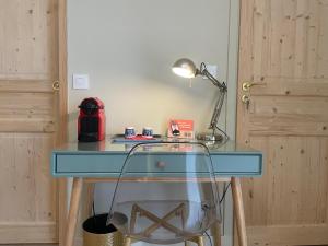 a glass desk with a lamp and a glass chair at Le temps des Pins in La Teste-de-Buch