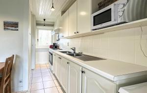 a white kitchen with a sink and a microwave at 2 Bedroom Nice Home In Rendeux in Rendeux