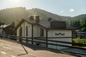 a building on the side of a road with a fence at Sherwood Chalet in Bukovel