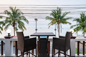 a table and chairs with a view of the beach at RimLay Beachfront Pool Villa in Sattahip