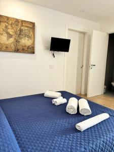 a blue bed with three white towels on it at A Casuzza di Giú Giú - NUOVA GESTIONE in Agrigento