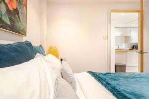 a bedroom with a bed with blue pillows at SkylightAnnex in Gaywood +5 photos
