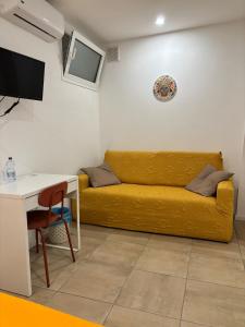 a living room with a yellow couch and a table at A Casuzza di Giú Giú - NUOVA GESTIONE in Agrigento