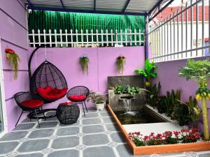 a purple room with two chairs and a koi pond at Ryo Homestay Dốc Lể in Ba Ha