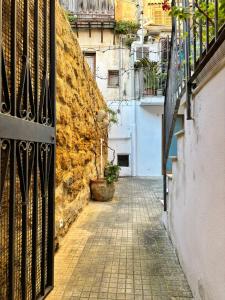 an alley with a gate and a stone wall at A Casuzza di Giú Giú - NUOVA GESTIONE in Agrigento
