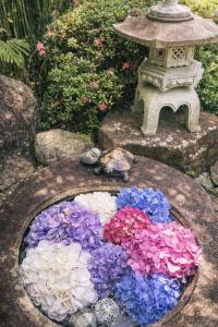a bowl filled with colorful flowers in a garden at ガーデンリゾート 潮美庵 in Hatsukaichi