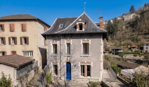 an old white house with a gray roof at Maison Maubert in Thiers
