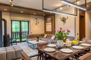 a dining room with a table and a couch at Sherwood Chalet in Bukovel