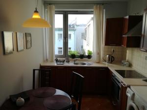 a kitchen with a table and a sink and a window at Apartamenty Sedinum - Modern in Szczecin