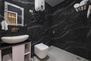 a black marble bathroom with a sink and a toilet at Sunrise Villa in Fagu +34 photos