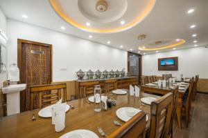 a restaurant with a large wooden table and chairs at Sunrise Villa in Fagu
