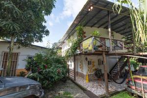 a house with a balcony and a staircase at Hostel Wunderbar in Puerto Lindo