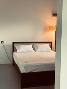 a bed with two pillows on it in a room at Greenora Resort in Katunayaka