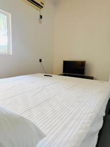 a large white bed in a room with a window at Greenora Resort in Katunayaka