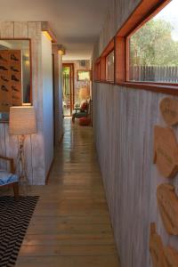 a hallway of a house with wooden floors and windows at Casapapudo Boutique Home in Papudo