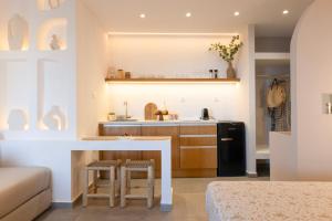 a kitchen with a sink and a counter with stools at Panorama Rooms in Anafi