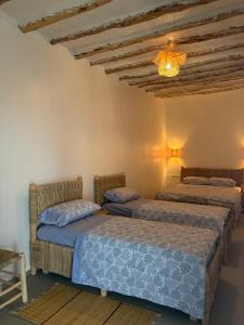 a bedroom with two beds and a ceiling at Darnamed in Nador
