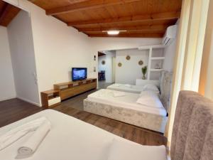 a large room with two beds and a television at Anel Studios in Vlorë