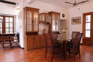 a kitchen with wooden cabinets and a table and chairs at The Polaris in Cochin