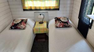 two beds in a room with a table and a lamp at Minicabin in Vuokatti