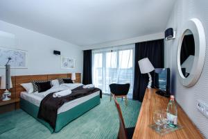 a hotel room with a bed and a television at Hotel Active in Szczecinek