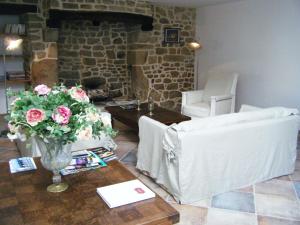 una sala de estar con un jarrón de flores sobre una mesa en Les chambres du Manoir de Kerhel, en Locoal-Mendon
