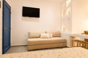 a living room with a couch and a flat screen tv at Panorama Rooms in Anafi