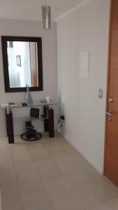 Habitación blanca con espejo y lavabo en Ovaser I, en Coquimbo
