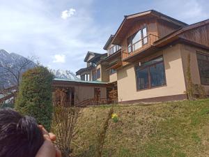 a person standing in front of a house at Golf view resort in Pahalgām