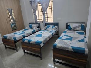 three beds sitting in a room with windows at Om Sai Ram Coliving in Bangalore