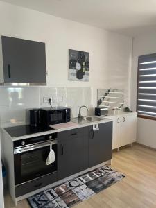 a kitchen with a black stove and a sink at Seafront Home in Larnaca