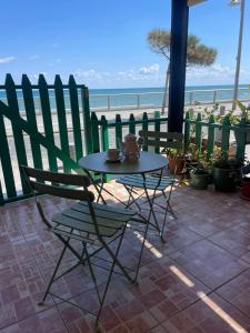 a table and chair with a view of the beach at Seafront Home in Larnaca +11 photos