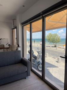 a living room with a couch and sliding glass doors at Seafront Home in Larnaca