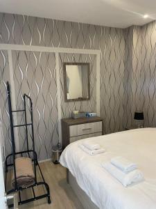 a bedroom with a bed and a mirror and a chair at Seafront Home in Larnaca