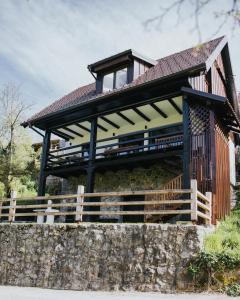 a large house with a roof on a stone wall at Riverside House Krka in Zagradec