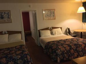 Postel nebo postele na pokoji v ubytování Ranch House Inn & Suites