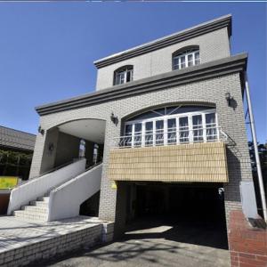 un grand bâtiment en briques avec une grande fenêtre et un garage dans l'établissement Hotel Select Inn Tsuyama, à Tuyama