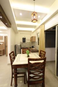 a kitchen and dining room with a table and chairs at Navrasa By CDF in Vrindāvan +7 photos