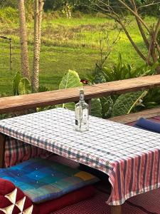a table with a glass bottle on top of it at Ponko Home in Ban Si Than +13 photos