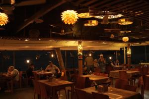 a restaurant with people sitting at tables in a room at Hotel Searock in Trivandrum