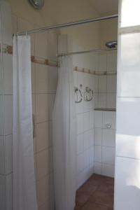 a shower with a white shower curtain in a bathroom at Abschalten und Kraft tanken im Wendland in Schreyahn +15 photos