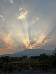 a sunset with the sun shining through the clouds at Ponko Home in Ban Si Than