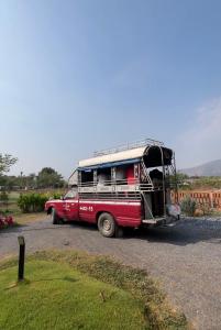 an old red bus is parked on a road at Ponko Home in Ban Si Than